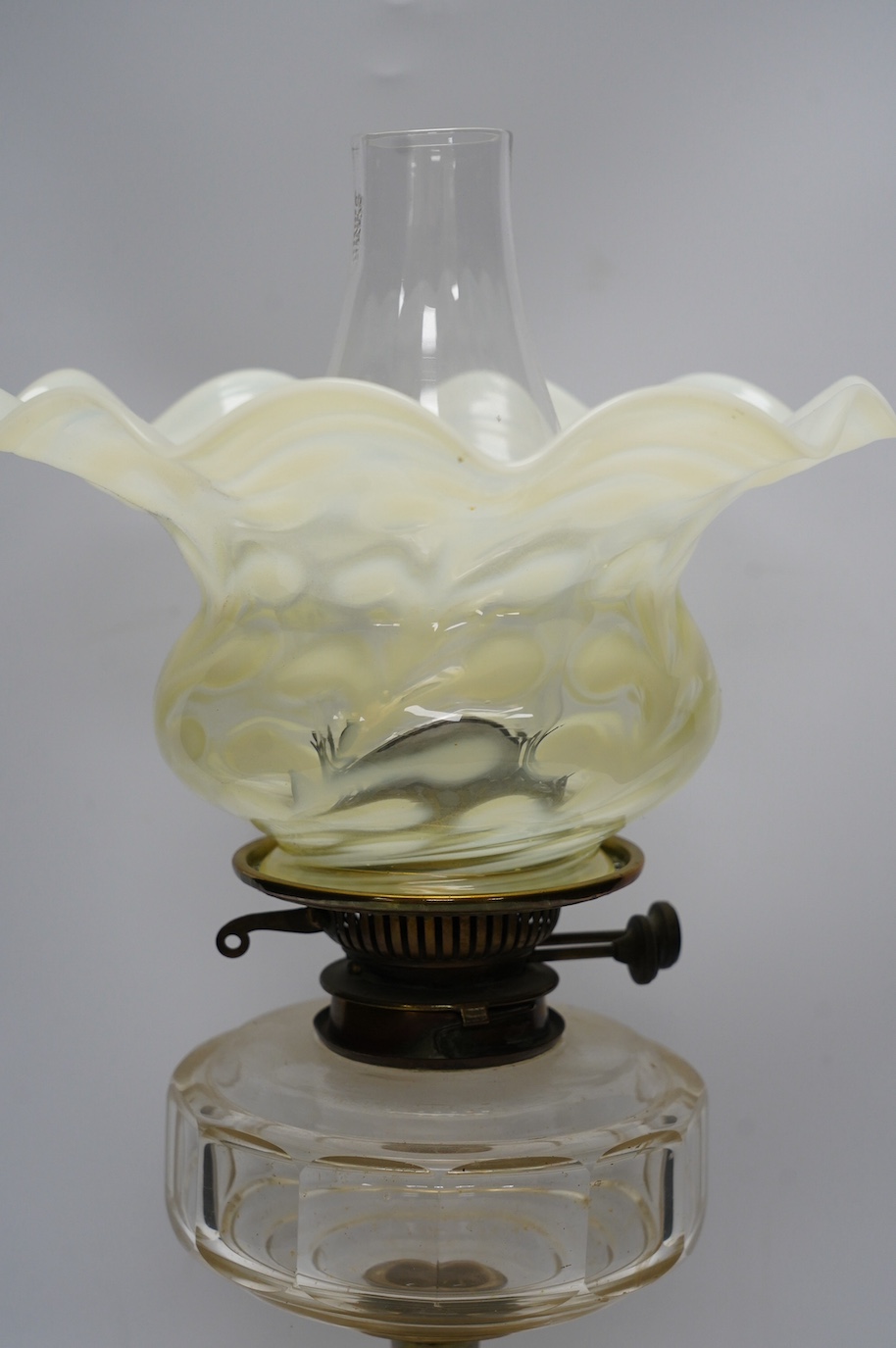 A brass oil lamp with glass reservoir and Art Nouveau vaseline glass fluted shade, 48cm high. Condition - good